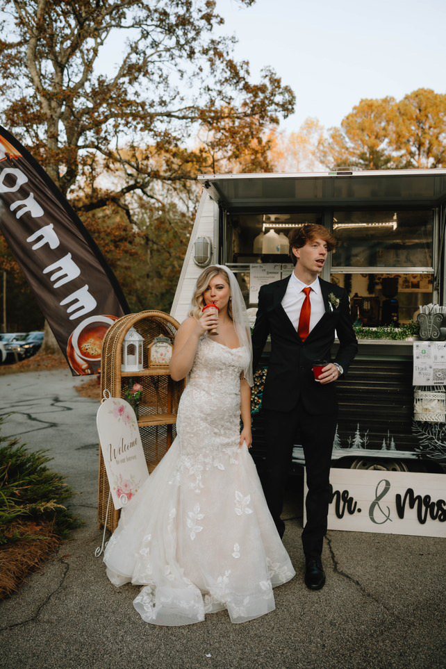 Bride and groom enjoying drinks beside Butterfly Mountain Coffee Camper