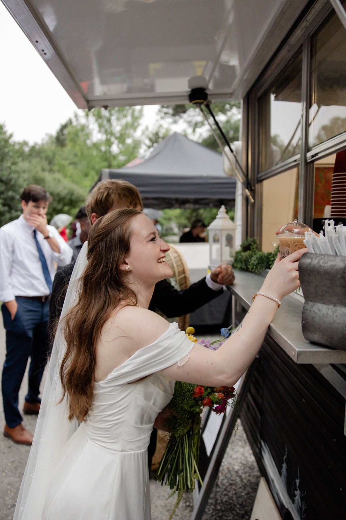 Bride smiling while ordering a drink from Butterfly Mountain Coffee Camper